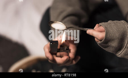 Selektiver Fokus der Süchtigen Mann kocht Heroin im Löffel auf leichtere Stockfoto