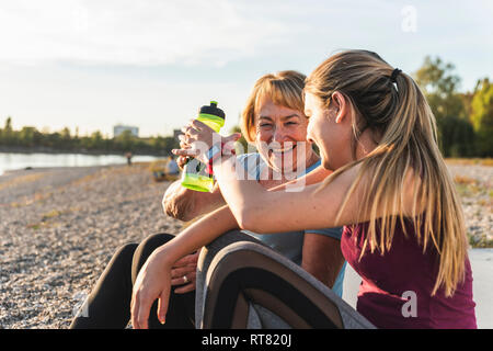 Großmutter und Enkelin eine Pause nach dem Training am Fluss Stockfoto