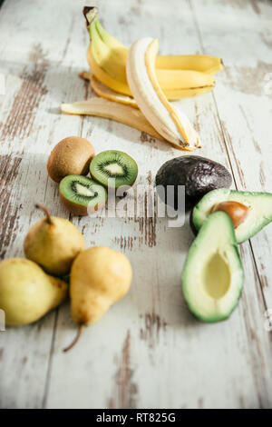 Birnen, geschält und ganze Banane, in Scheiben geschnitten und ganze Avocado und Kiwi Stockfoto