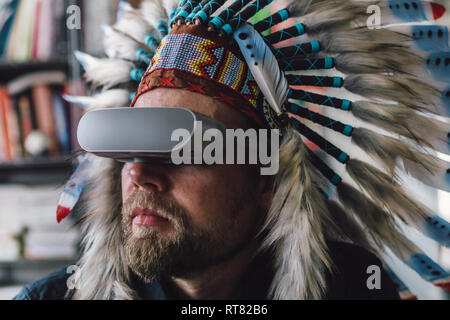 Mann mit indischen Kopfschmuck und VR-Brille im Büro Stockfoto