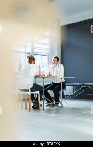 Arzt im Gespräch mit Patienten in der medizinischen Praxis Stockfoto