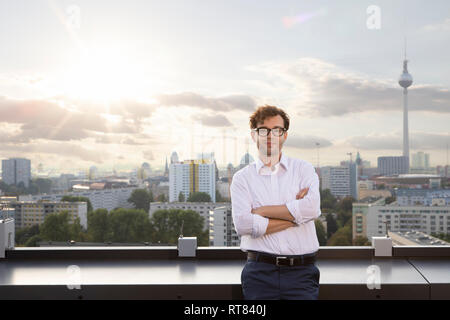 Deutschland, Berlin, Porträt von lächelnden Geschäftsmann auf der Dachterrasse am Abend Stockfoto