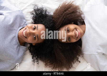 Oben Ansicht afrikanischen Tochter und Mutter liegend auf Bett Stockfoto
