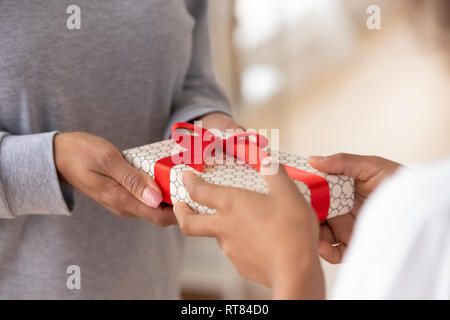In der Nähe der Frauen Hände halten eine Geschenkverpackung Stockfoto