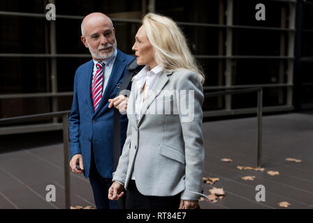 Senior Geschäftsmann und Geschäftsfrau wandern und Sprechen in einem Foyer Stockfoto