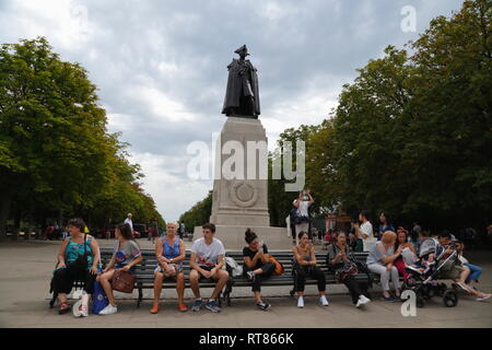 Die Leute sitzen auf einer Bank vor der Bronzestatue von James Wolfe, der Victor von Quebec, in Greenwich, London, Vereinigtes Königreich. Stockfoto