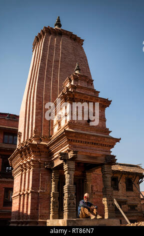 Nepal, Kathmandu Tal, Bhaktapur, Durbar Square, Kedarnath Shiva Tempel, rekonstruiert nach dem Erdbeben 2015, Mann im Schatten der Eingang sat Stockfoto