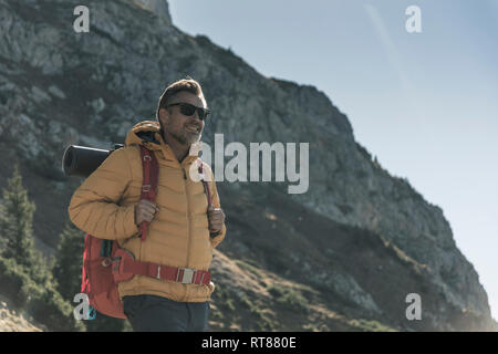 Österreich, Tirol, lächelnden Mann mit Sonnenbrille Wandern in den Bergen Stockfoto