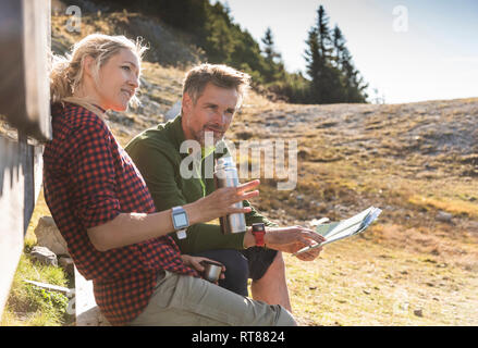 Wandern Paar vor der Hütte sitzen, eine Pause Stockfoto