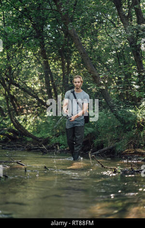 Junger Mann angeln in einem Wald Stockfoto