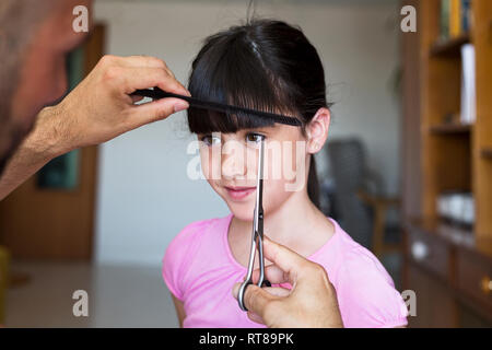 Vater Haare schneiden's Tochter zu Hause Stockfoto