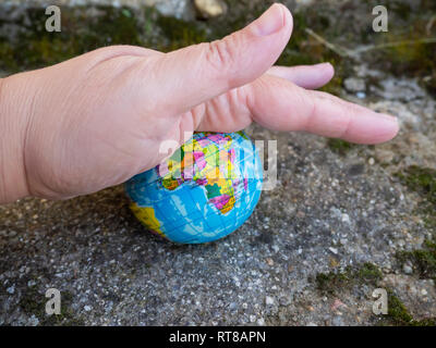 Eine Person zu zerstören, mit seiner Hand eine erdkugel oder Planeten Erde. Konzept der Ökologie Stockfoto
