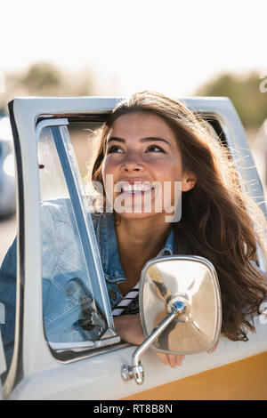 Hübsche Frau auf einer Fahrt mit Ihrem Wohnmobil, Blick aus dem Fenster Stockfoto