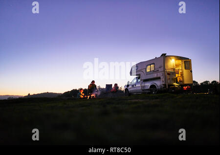 Chile, Talca, Rio Maule, Mutter mit zwei Söhnen am Lager Feuer an Camper sitzen Stockfoto