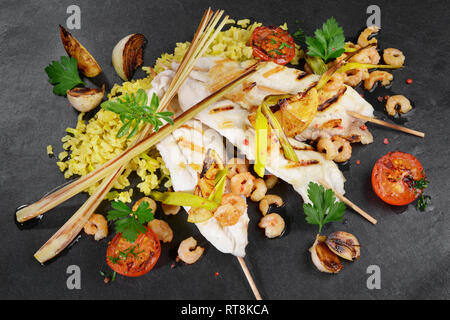 Plattfisch Filet mit Garnelen auf schwarzem Schiefer Stockfoto