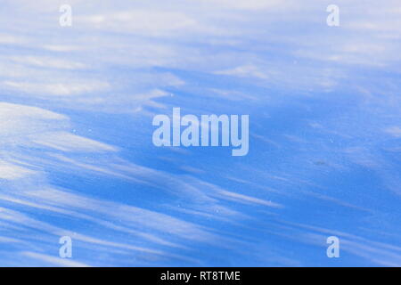 Der Wind hat Muster in den Schnee, einen zugefrorenen See gebildet. Stockfoto