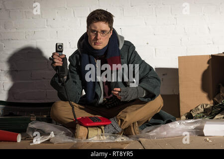 Mann in Gläser halten roten Jahrgang Telefon Stockfoto