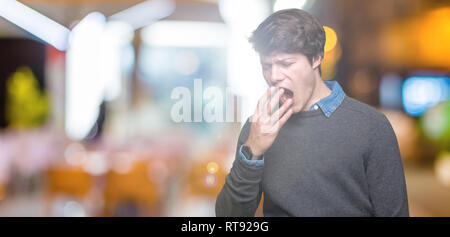 Junge schöne elegante Mann über isolierte Hintergrund Gähnen müde über den Mund mit der Hand gebohrt. Rastlos und Schläfrigkeit. Stockfoto