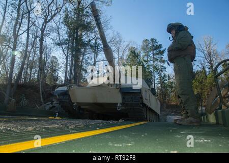 Us Marine Corps Cpl. Mascimiliano Reyes, 2 Tank Battalion, 2nd Marine Division (MarDiv), inszeniert eine M1A1 Abrams tank auf ein verbessertes Farbband Brücke während einer Firma ebene Übung in Camp Lejeune, N.C., Jan 25, 2019. Marines mit Brücke, 8 Techniker, 2. Marine Logistics Group, die Brücke mehr als ein Dutzend Panzer über den neuen Fluss zu transportieren die 2 MarDiv Einheit zu unterstützen. Stockfoto