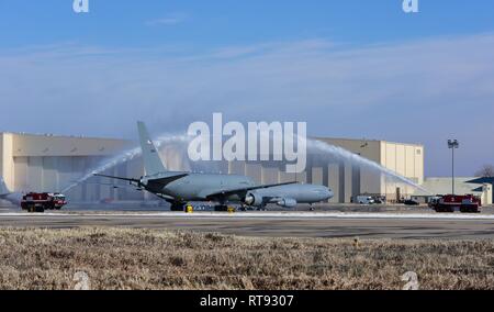 Löschfahrzeuge zur 22 Bauingenieur Geschwader zugewiesen, um ein Wasser durchführen - begrüssen, während die erste KC-46A Pegasus Taxis zum Hangar 1126 Jan. 25, 2019, McConnell Air Force Base, Kan. Betreuer abgeschleppt das Flugzeug an der Vorderseite eines Hangars während der KC-46 Ankunft Zeremonie vorgestellt werden. Stockfoto