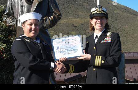 SAN FRANCISCO, Kalifornien (Jan. 25, 2019) Operations Specialist 2. Klasse Grisel Ramirez, von Tampa, Florida, ein Personalvermittler zu Marine-einziehende Bezirk San Francisco zugeordnet Reenlisted für sechs weitere Jahre an der Lone Sailor statue am nördlichen Ende der Golden Gate Bridge. Stockfoto