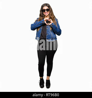 Junge schöne Frau mit Sonnenbrille in der Liebe mit Herz und mit Hand lächelnd. Romantische Konzept. Stockfoto