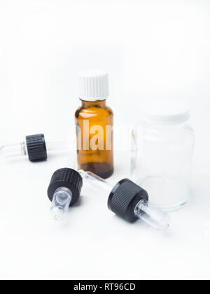 Braune und weiße Medizin Glasflaschen mit Dropper auf weißem Hintergrund, Pipetten isoliert, Medizinische Bank Stockfoto