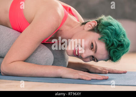 Grün - behaarte Frau tragen rosa Top arbeiten an Sport mat Stockfoto