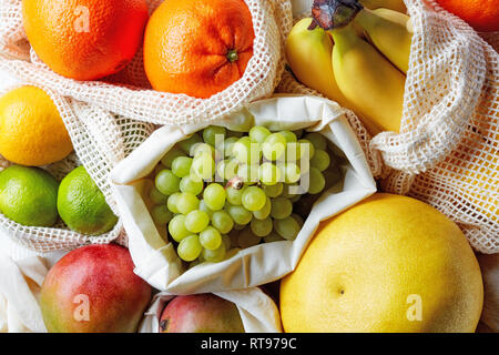 Frische Früchte in Baumwolltaschen, umweltfreundlich und null Abfall shopping Konzept, Bananen, Orangen, Limonen, Zitronen, Trauben, Mangos und pomelo aus Markt Stockfoto