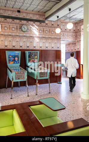 Flipperautomaten, Juke Box und pastellfarbenen Möbeln an der Bar Luce, Wes Anderson inspirierte Bar und Cafe in der Fondazione Prada in Mailand, Italien Stockfoto