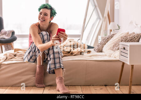 Frau nach dem Lesen der Nachricht von Freund am Morgen Stockfoto