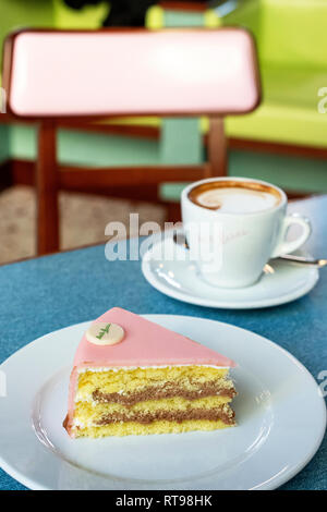 Cappuccino, Torta Rosa und mit pastellfarbenen Möbeln an der Bar Luce, Wes Anderson inspirierte Bar und Cafe in der Fondazione Prada in Mailand, Italien Stockfoto