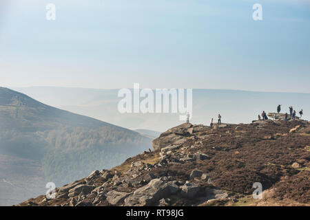 Wanderer und Touristen auf Bamford Kante im Peak District mit Blick über die Landschaft in Richtung Hügel verlieren und Mam Tor in der Ferne auf der Winter da Stockfoto