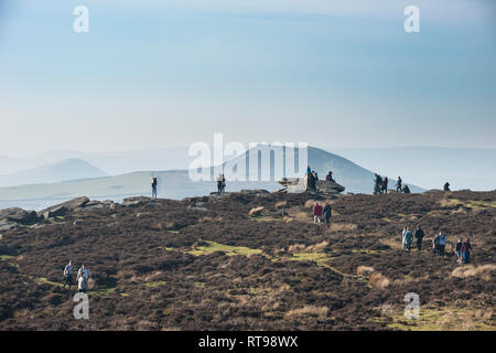 Wanderer und Touristen auf Bamford Kante im Peak District mit Blick über die Landschaft in Richtung Hügel verlieren und Mam Tor in der Ferne auf der Winter da Stockfoto