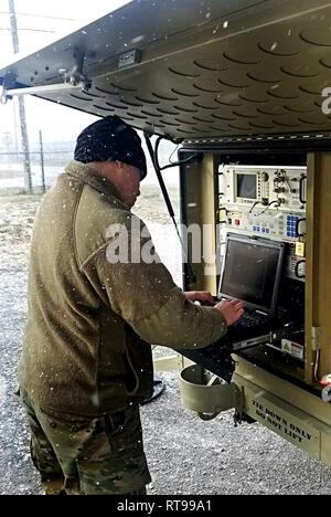 Sgt. Alexander Korte, Alpha Company, 156 Expeditionary Signal Battalion, Team Chief, Sat-Terminal Abschnitt, Michigan National Guard, arbeitet mit Marcus Blakely, Field Service Representative, U.S. Army Signal Communications-Electronics Befehl, passt die Einstellungen auf dem Satelliten Transportable Terminals (STT) die Gemeinsame Network Node (JNN), Fütterung während einer Task Force 46 (46th Military Police Command) Kommunikation Übung an der freiwilligen Training Website, Tennessee National Guard, Smyrna, Tenn., Jan 30, 2019. (Michigan National Guard Stockfoto