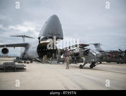 NAVAL STATION Rota, Spanien (Januar 30, 2019) Soldaten der 1. Gepanzerten Division und 1109Th Theater Luftfahrt Sustainment Instandhaltungsgruppe zugeordnet ein AH-60 Apache Helikopter auf einem C-5 Flugzeugs für den Kombinierten Verkehr. Intermodale Operationen kombinieren, zu Wasser und in der Luft cargo handling zu verringern, die Sicherheit zu verbessern, Schäden zu minimieren und schneller Transport ermöglichen. Stockfoto