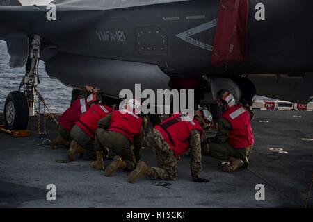 Marines mit der F-35 B Blitz II Loslösung von mittlerer Marine Tiltrotor Squadron 262 (Verstärkt) eine F-35B Kämpfer für ein inertes vorbereiten Guided bomb Unit auf dem Flight Deck an Bord der Amphibisches Schiff USS Wasp (LL 1), Philippine Sea, Jan. 26, 2019. Die F-35 B wird eine Reihe von Waffen, darunter geführte Bomben und Raketen - Die multirole Fighter ist das Marine Corps' neuesten, Angriff jet und ist für Navy-Marine Corps amphibische Operationen gebaut. Die 31. MEU, das Marine Corps' nur kontinuierlich vorwärts - bereitgestellt MEU partnering mit dem Wasp amphibischen bereit, Gruppe, Stockfoto