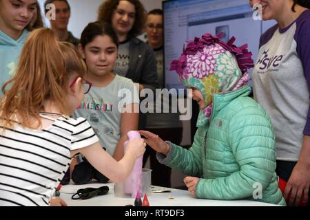 Coco Muth, 6, Rechts, berührt eine schäumende Mischung, die aus einer chemischen Reaktion aus Spülmittel, Backpulver, Wasser und Hefe während einer Wissenschaft, Technologie, Ingenieurwesen und Mathematik workshop Januar 26, 2019, im Grand Forks Öffentliche Bibliothek. Muth war einer von mehreren Kindern, besuchte die Stammzellen Workshop von Grand Forks Air Force Base, North Dakota, das speziell für Mütter konzipiert wurde zusammen mit ihren Töchtern über elektrische, mechanische und chemische Technik zu erlernen. Stockfoto