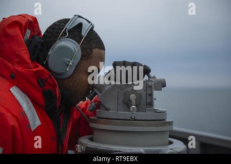 Atlantik (Jan. 28, 2019) der Bootsmann Mate 3. Klasse Jaavon Turner, aus Kansas City, Mo, nimmt das Lager der einen Kontakt mit der Backbordseite alidade an Bord der Arleigh-Burke-Klasse geführte Anti-raketen-Zerstörer USS Bainbridge (DDG96) während der Composite Trainingsgerät Übung (COMPTUEX), 31.01.28. Bainbridge Zurzeit ist die Durchführung von COMPTUEX mit Carrier Strike Group (CSG) 12. Die Komponenten der CSG 12 verkörpern ein "Team-von-Teams" Konzept, die moderne Oberfläche, Luft und Systeme zu erstellen und die operativen Fähigkeiten unterstützen. Auf diese Weise sind sie für den globalen Betrieb verhalten vorzubereiten Stockfoto