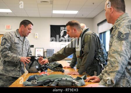 Senior Master Sgt. Shaun Lagrange, eine flugzeugbesatzung Flug Ausrüstung Techniker 180 Fighter Wing, Ohio Air National Guard zugeordnet, lehrt Staff Sgt. Zach Yeckley und Tech. Sgt. Adam Berry, (von links nach rechts), die auch an die 180 FW, zugeordnet, wie man richtig und effizient und einem Helm entfernen Vor dem Empfang incentive Flüge, Jan. 28, 2019, Patrick Air Force Base in Florida. Die 180 FW im Einsatz mehr als 130 Piloten und 10 F-16s an Patrick in einer Bemühung, Flugbetrieb und Bereitschaft, Fähigkeiten, die häufig von den harten Winter Wetter zu Hause behindert werden kann zu verbessern - Station in Nort Stockfoto