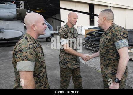 Us Marine Corps Oberstleutnant Kevin Hunter, kommandoinstanz Marine schweren Helikopter Squadron 463, und Sgt. Maj. Jacob H. Rozelle (Mitte), Sergeant Major, willkommen Generalmajor Vincent Coglianese, Commander, Marine Corps Installationen Befehl des Geschwaders, während einer Tour von Marine Corps Base Hawaii (MCBH), Jan. 28, 2019. Gen. Coglianese besucht Marine Corps Air Station Kaneohe Bay und CLB-3, Konferenz der US-Marines stationiert am MCBH. Stockfoto