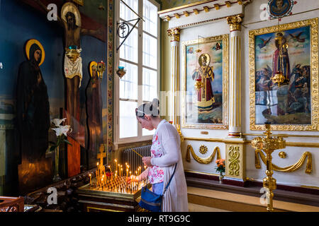 Lettland: Riga. Im neo-klassischen Stil St. Alexander Nevsky Kirche, in der Straße, eine Frau, eine Kerze anzünden. Die Hälfte der Bevölkerung ist Riga Stockfoto