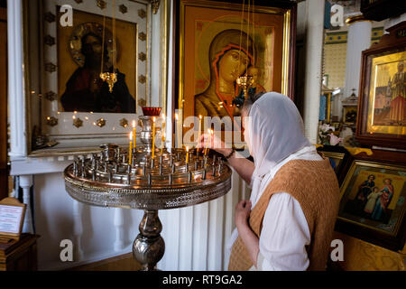 Lettland: Riga. Riga. Im neo-klassischen Stil St. Alexander Nevsky Kirche, in der Straße, eine Frau bekleidet Fichu auf ihrem Kopf Beleuchtung ein kann Stockfoto