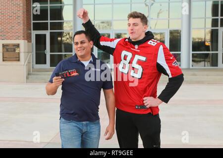 FORT Benning, Ga (Jan. 29, 2019) - erasmo 'Moe "Espino, 2014 Tillman Stiftung Gelehrter und 15 Jahre Armee Veteran, erhält zwei Eintrittskarten für das 2019 Super Bowl von Eric Saubert, Atlanta Falcons festes Ende, bei Mc Ginnis-Wickam Hall, Fort Benning, Georgia, während der NFL Gruß zu Service Jan. 29, 2019. Die NFL und USO kamen zusammen, um die Veranstaltung, inklusive einem Treffen mit Atlanta Falcons Spielern und Cheerleadern zu werfen. Stockfoto