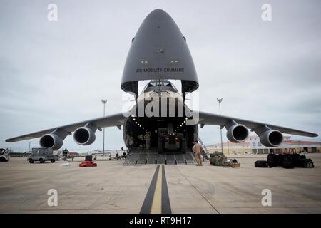 NAVAL STATION Rota, Spanien (Jan. 29, 2019) Seabees zu Naval Mobile Konstruktion Bataillon (NMCB) 1 und US Air Force (USAF) Flieger zur 22 Airlift Squadron download U.S. Army M 777 haubitzen von einem USAF C 5 M Super Galaxy während einer Einschiffung Betrieb zugewiesen. NMCB-1 wird eingesetzt, der humanitären Hilfe und der ausländischen Hilfe auszuführen, und das Theater für die Zusammenarbeit in den USA 6 Flotte Bereich der Operationen. Stockfoto