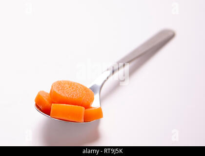 Einen Esslöffel essen. Teil Kontrolle. Gekochte Karotten. Stockfoto