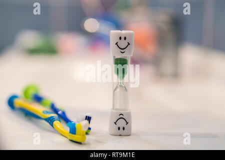 Konzept der empfohlenen Zeit Zähne zu putzen. Soft Focus. Zwei Zahnbürsten und Sanduhr. Zähneputzen für 3 Minuten. Stockfoto