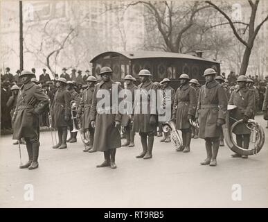 Soldaten der 369. Infanterie Regiment Band stand auf der Rest, wie Sie warten bis März der Fifth Avenue in New York City am 13.02.17, 1919 während einer Parade statt der New York National Guard unit home Herzlich willkommen. Mehr als 2.000 Soldaten nahmen an der Parade auf der Fifth Avenue. Die Soldaten zogen sieben Meilen von der Innenstadt von Manhattan nach Harlem. Die Band wurde vom renommierten Musiker Leutnant James Reese' Jimmie "Europa, in der Mitte mit Brille gesehen. (National Archives) Stockfoto