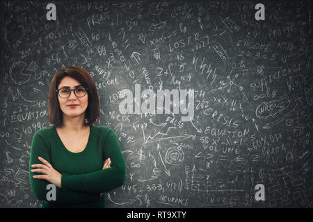 Zuversichtlich Geschäftsfrau Brille vor einer Tafel die Lösung schwer Mathematik Berechnung stehend, Wirtschaftswissenschaften Formeln und Gleichungen. Denken Stockfoto