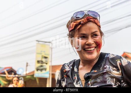 Vang Vieng, Laos - April 14, 2018: Nass lokale Mädchen lächelnd auf der Straße, während die Laotische Neujahrsfest Stockfoto